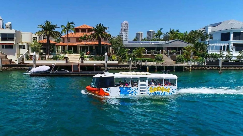 A water taxi moving through a marina with buildings and palm trees in the background. 4