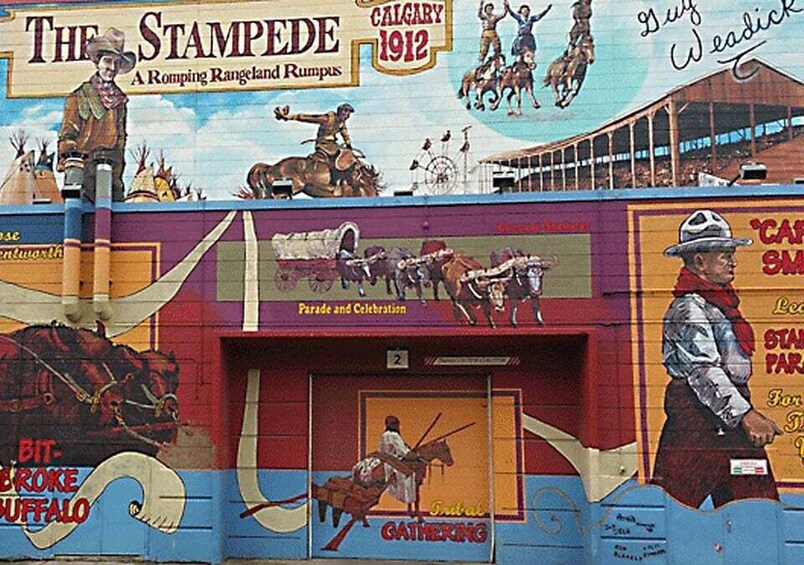 A mural of a Stampede parade with horses, riders, and a cowboy. 2