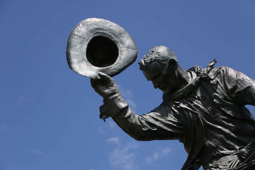 A statue of a man holding a hat. 1