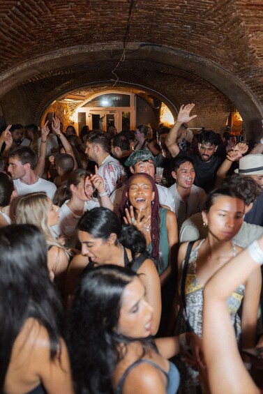 A crowded indoor space with a brick archway and a person standing at the entrance. 5