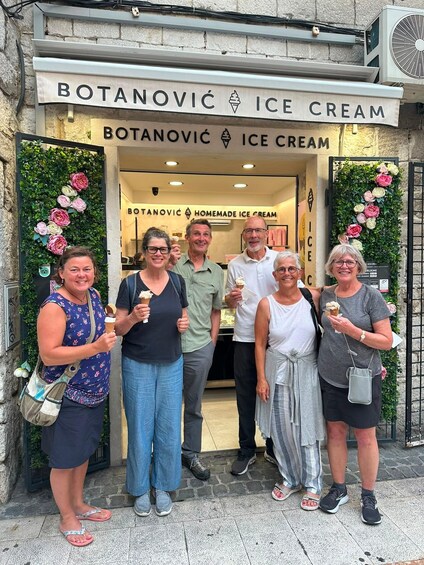 A group of people outside a shop named 'Botanovíc Ice Cream' with a sign indicating it sells homemade ice cream. 4