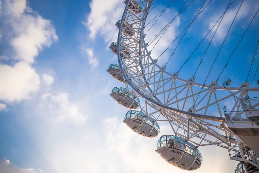 A Ferris wheel with multiple cabins against a clear sky. 3