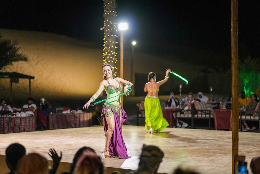A nighttime outdoor performance with dancers in colorful costumes. 1