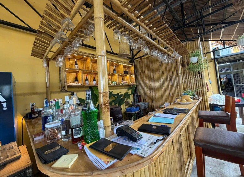 A bar with a bamboo ceiling and shelves stocked with bottles. 3