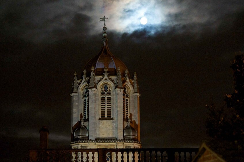 En kirke med en stor kuppel og et kors på toppen, under en overskyet nattehimmel. 3