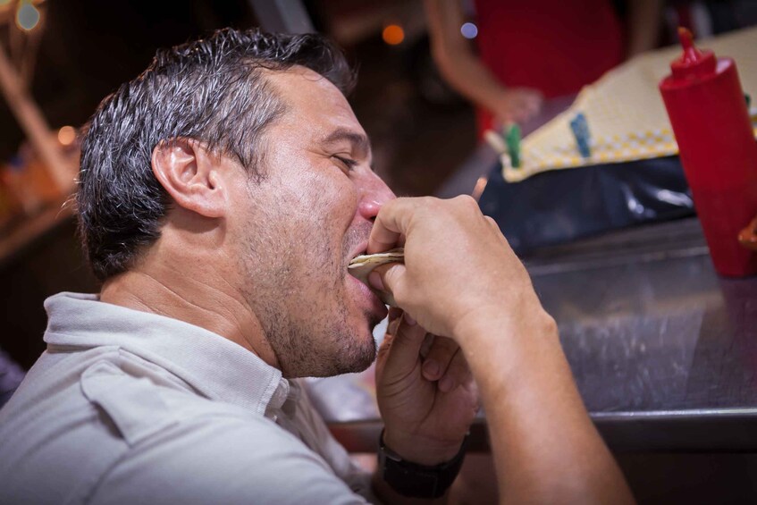 A person eating a small food item. 5