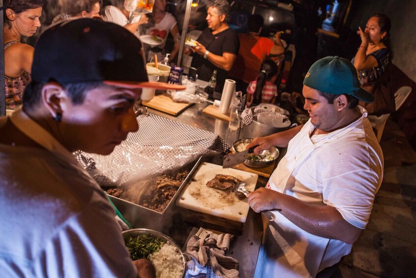 A street food vendor preparing food at a busy outdoor market. 3