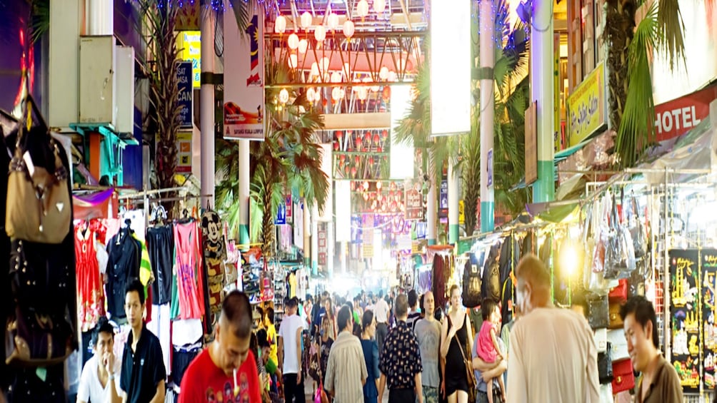 A crowded indoor market with various stalls and people shopping. 4