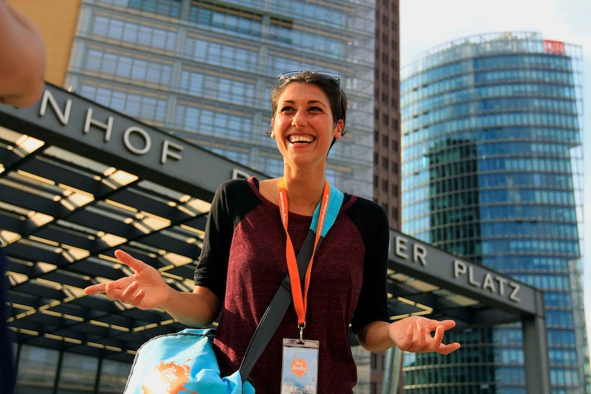 A person standing in front of a building with a sign that reads "NHOF PLATZ". 1