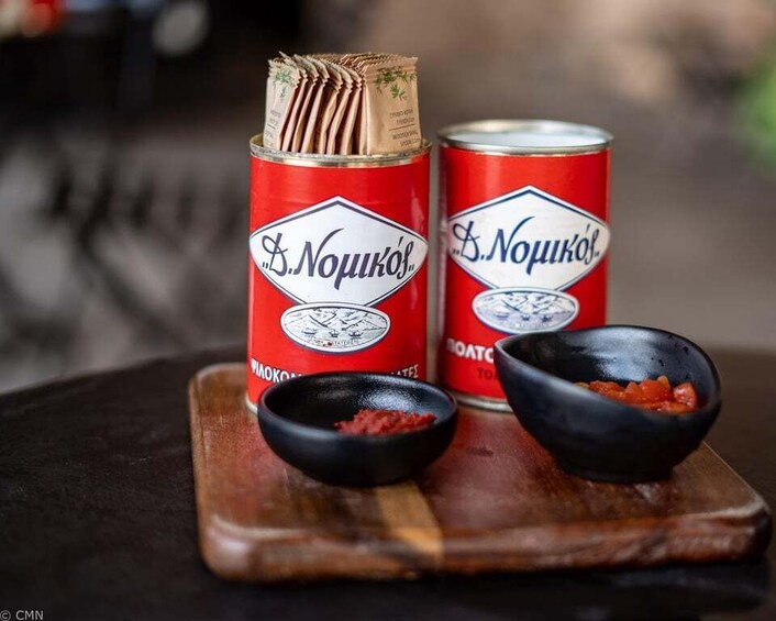 Two cans of B.Noukov's beer, a wooden board with two black bowls, one with red seasoning and one with a brown substance. 3