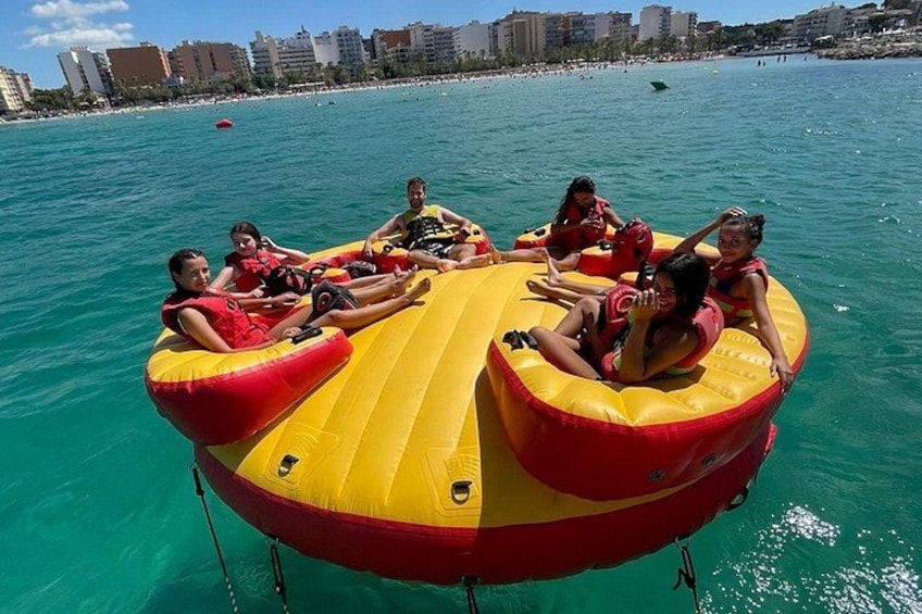 A group of people on a yellow and red inflatable raft in clear blue water. 1