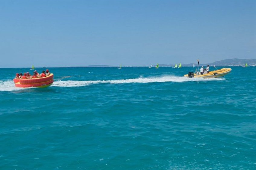 A red inflatable boat and a yellow speedboat on a turquoise sea with a clear sky. 2