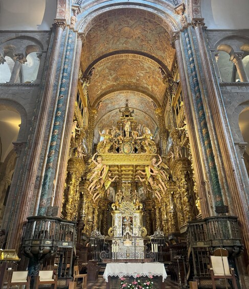 Ein prunkvolles Kircheninnere mit goldenem Altar, aufwendigen Deckenfresken und klassischen Säulen. 5