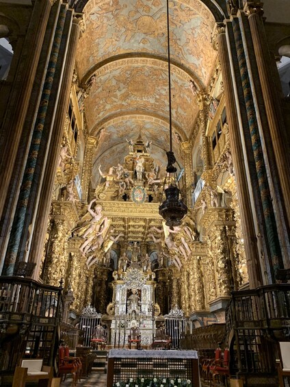 Ein prunkvolles Kircheninnere mit vergoldeten Statuen und kunstvollen Deckenmalereien. 4