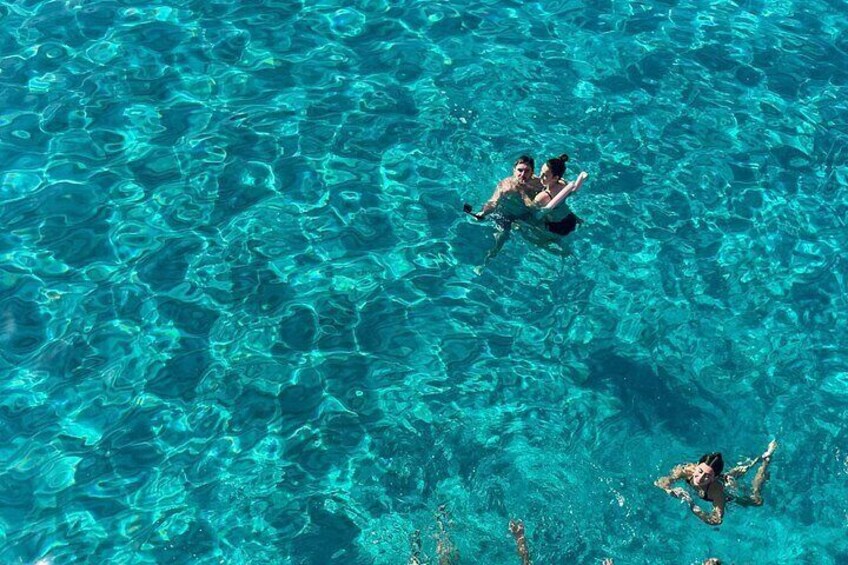 Dos personas nadando en aguas cristalinas azules. 1