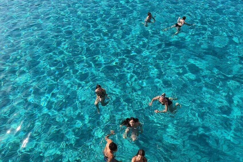 People swimming in clear blue water. 3