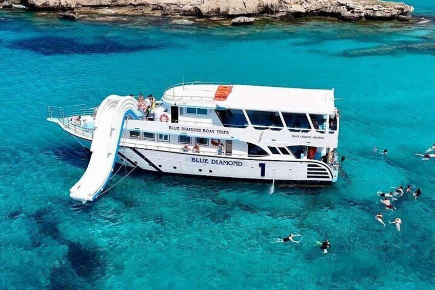 A boat named 'Blue Diamond' with a water slide, surrounded by clear turquoise water. 2