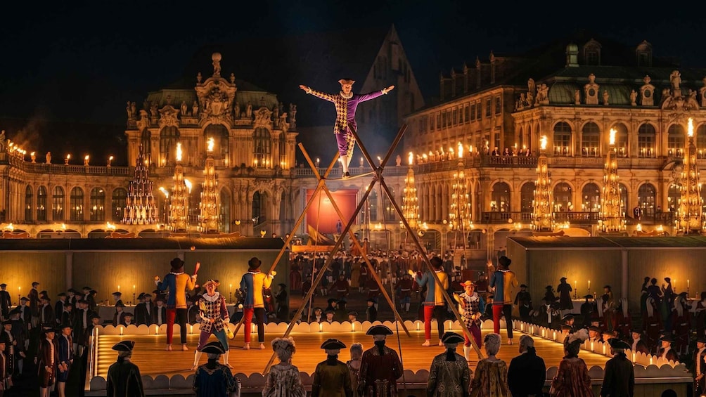 A historical reenactment with a central figure on a crossbeam, surrounded by spectators in period costumes. 2