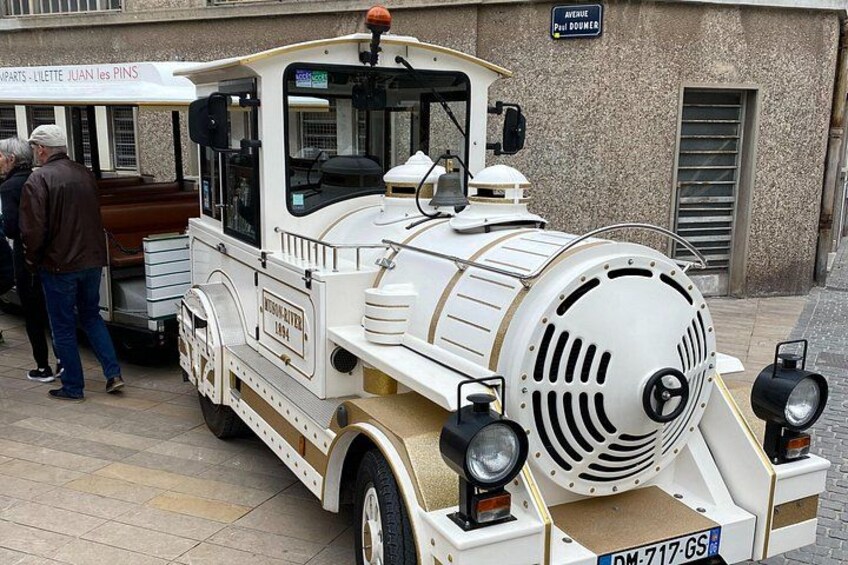 Un vieux camion blanc est garé dans une rue où des piétons passent. 3