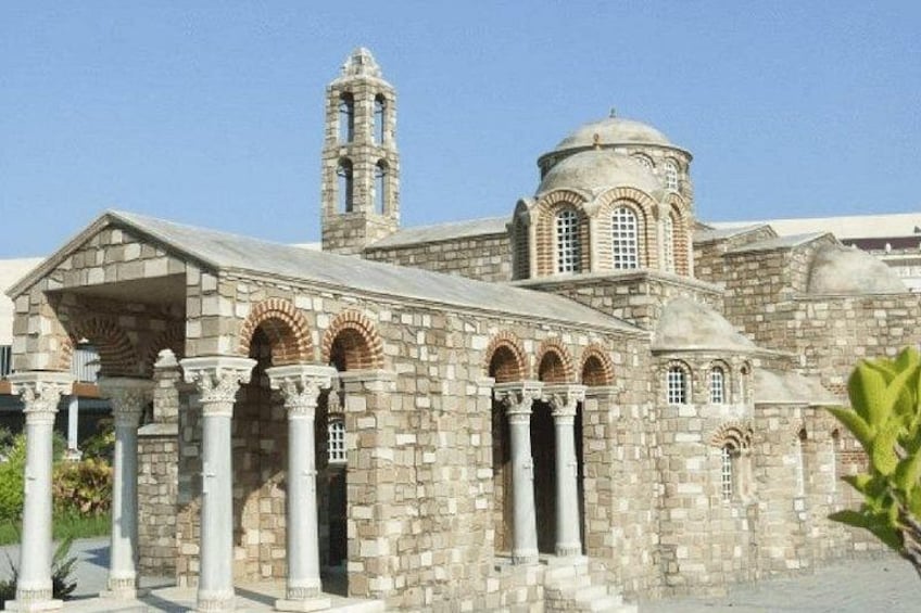 Un edificio de piedra con arcos, columnas y un campanario. 5