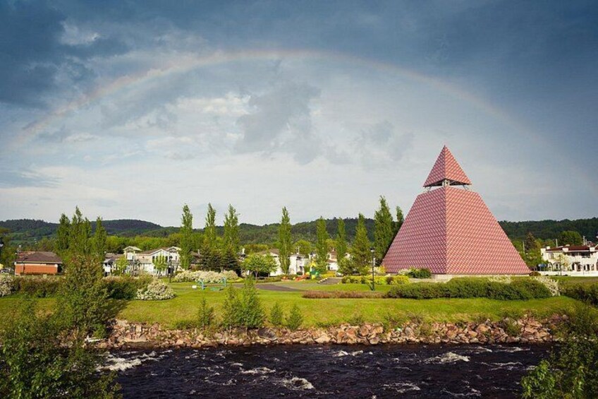 A pyramid-shaped building, a river, and houses in a rural setting. 4