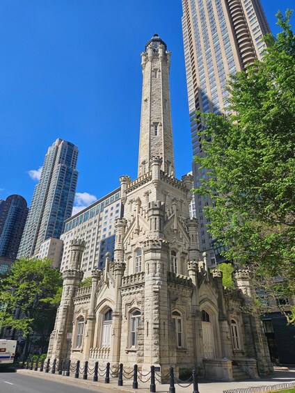 Un edificio histórico de piedra con arquitectura intrincada, rodeado de modernos rascacielos. 4