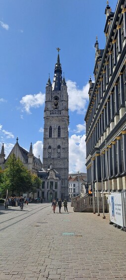 Ein historischer Platz mit einem markanten Glockenturm, Kopfsteinpflaster und klassischer Architektur. 3