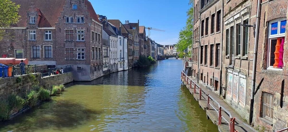 Ein schmaler Kanal, gesäumt von historischen Backsteingebäuden, mit einer Brücke darüber. 1