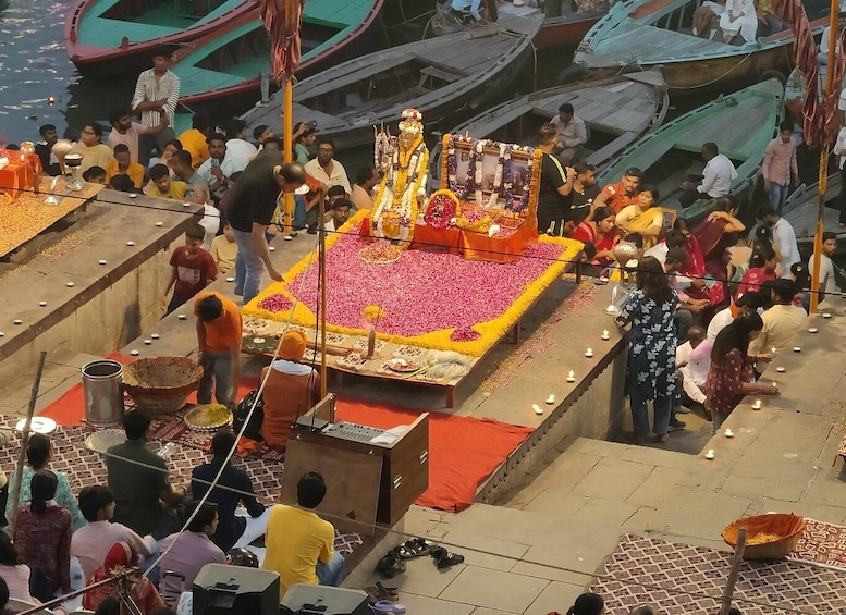 A riverbank with a decorated platform and boats. 1