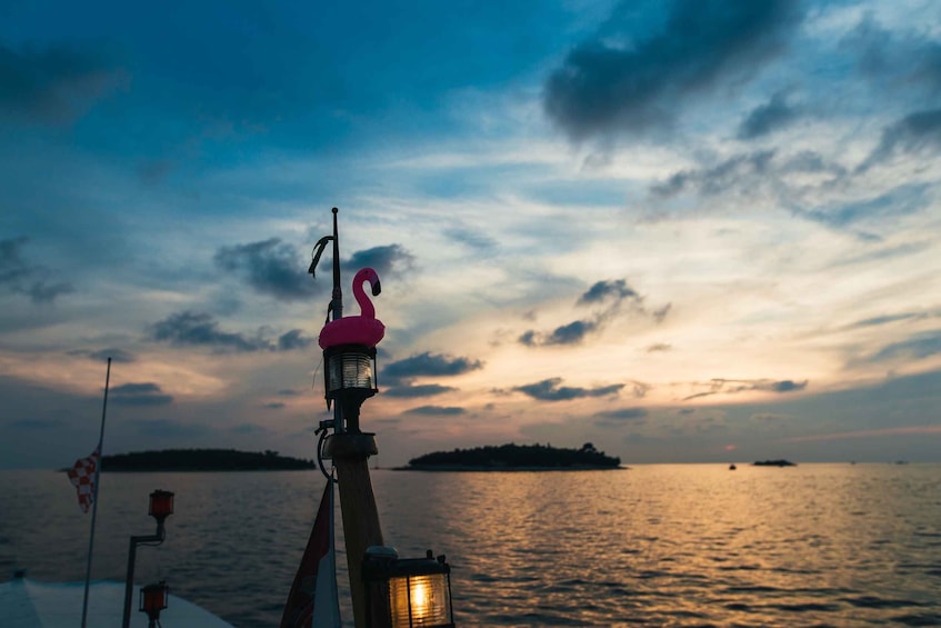 A sunset over a calm sea with a lighthouse in the foreground. 1