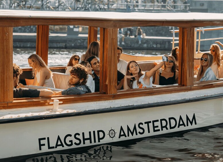 A boat named 'FLAGSHIP AMSTERDAM' with passengers taking photos. 2