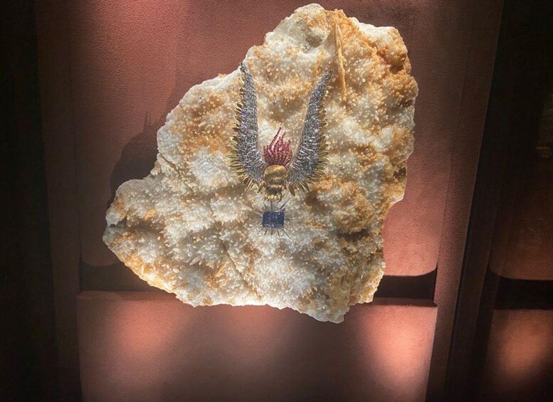 A rock with a blue pendant and a red and white object on it. 4