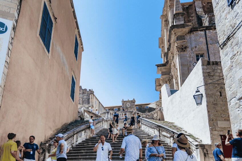 A crowded staircase in a historic town with tourists and locals ascending and descending. 5