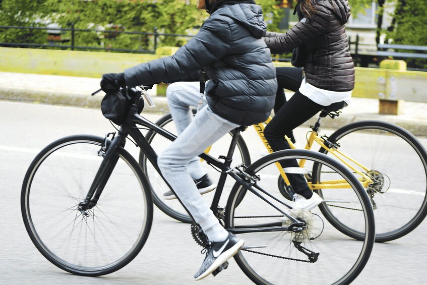 Dos personas andando en bicicleta por una calle de la ciudad. 2