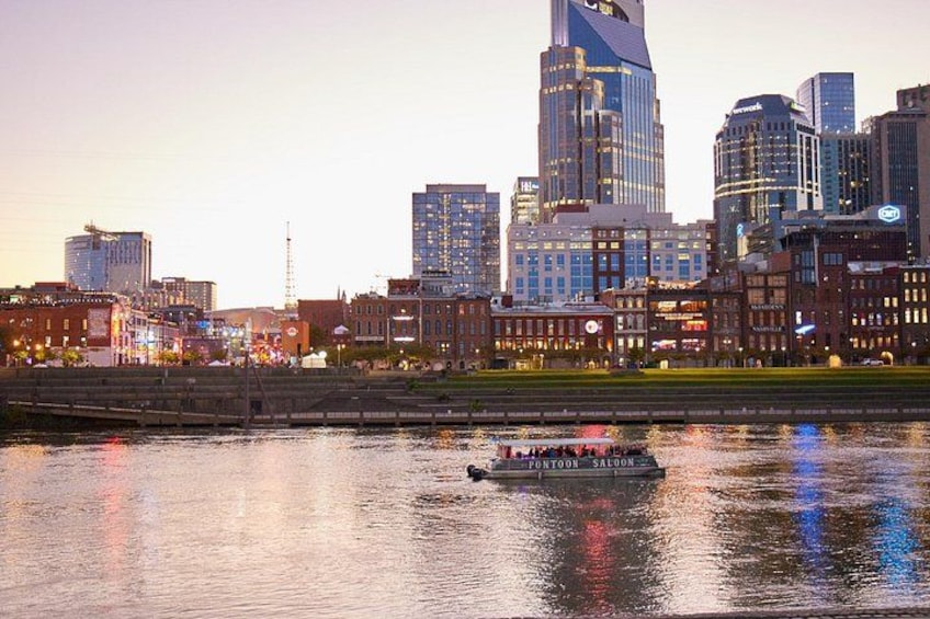A city skyline with modern buildings, a river, and a boat. 5