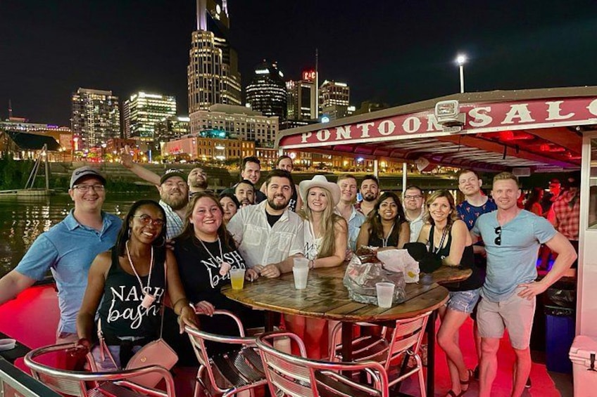A group of people on a boat with a city skyline in the background. 4