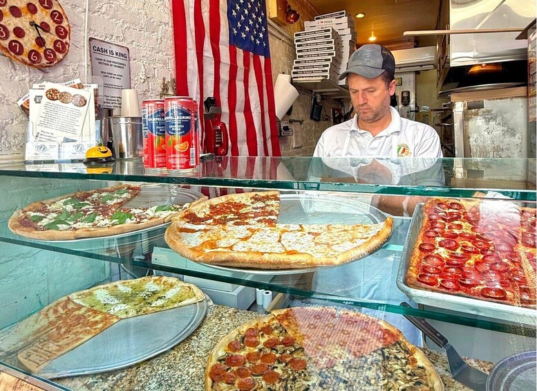 A pizza shop with various pizzas displayed in the window. 2