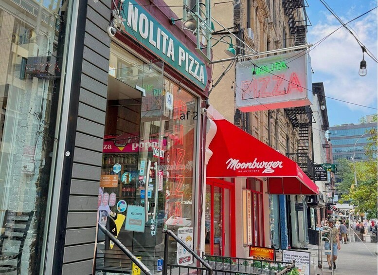 A street view with a pizza shop named 'NOLITA PIZZA' and a Moonburger restaurant. 4