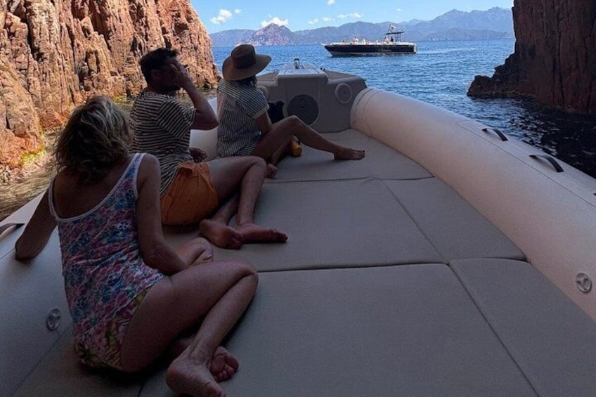 People sitting on a boat near rocky cliffs. 3