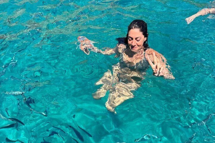 A person swimming in clear blue water. 2