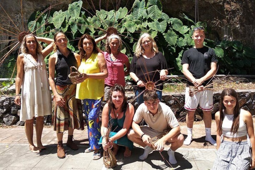 Un grupo de personas al aire libre, algunas sosteniendo objetos que parecen artefactos tradicionales o culturales. 3