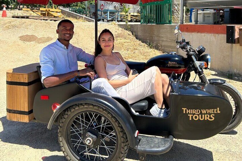A man and woman in a third wheel tour vehicle. 4