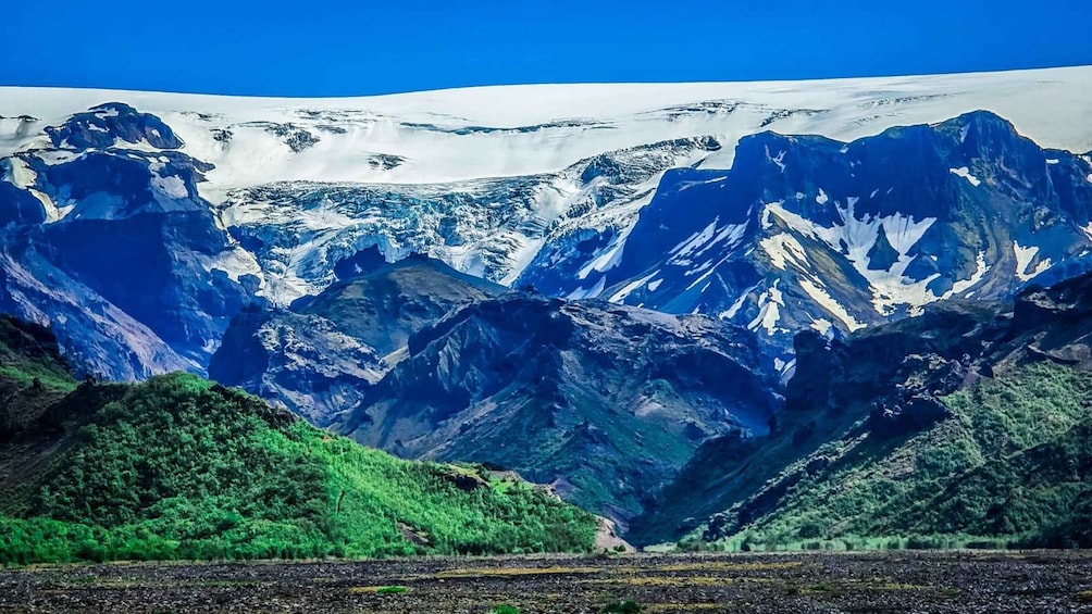 A mountain range with snow-capped peaks and lush green valleys. 4
