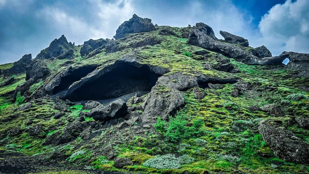 A rugged mountain landscape with prominent rock formations and patches of green vegetation. 5