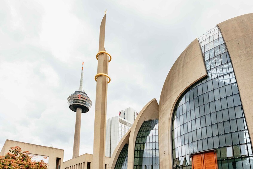 A modern building with a tall tower and a large arched window. 5