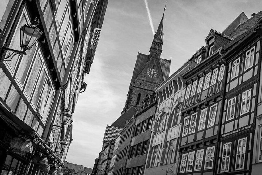 Eine Straße mit traditionellen Fachwerkhäusern, einem Glockenturm und einem Kirchturm. 2