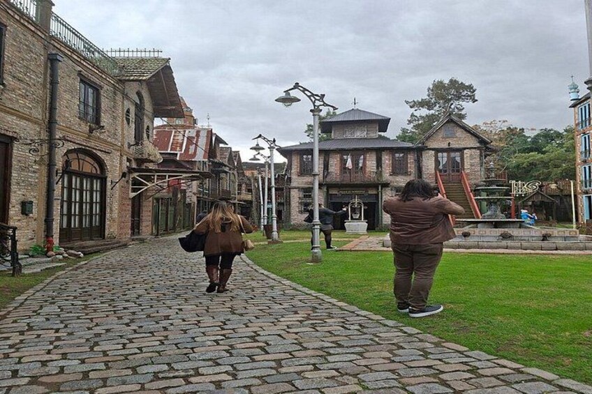 Een straat met kinderafsluiting, met historische gebouwen, een gazon en een fontein. 5
