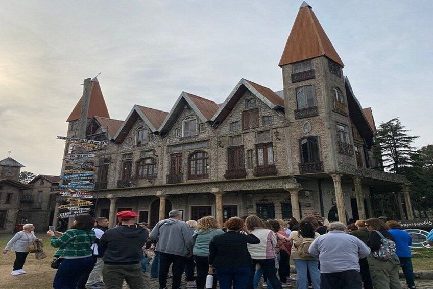 A historic building with multiple towers and a crowd of people in front. 2