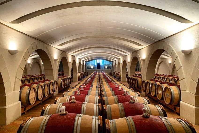 Una bodega con hileras de barriles de madera y techos abovedados. 1