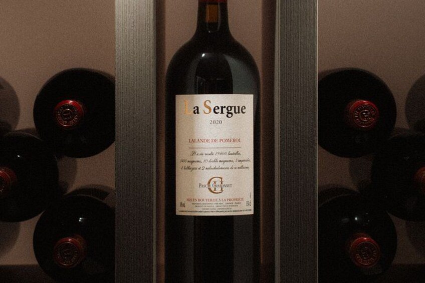 Una botella de vino etiquetada como 'laSergue 2020', con una etiqueta que muestra texto y un logotipo. 2